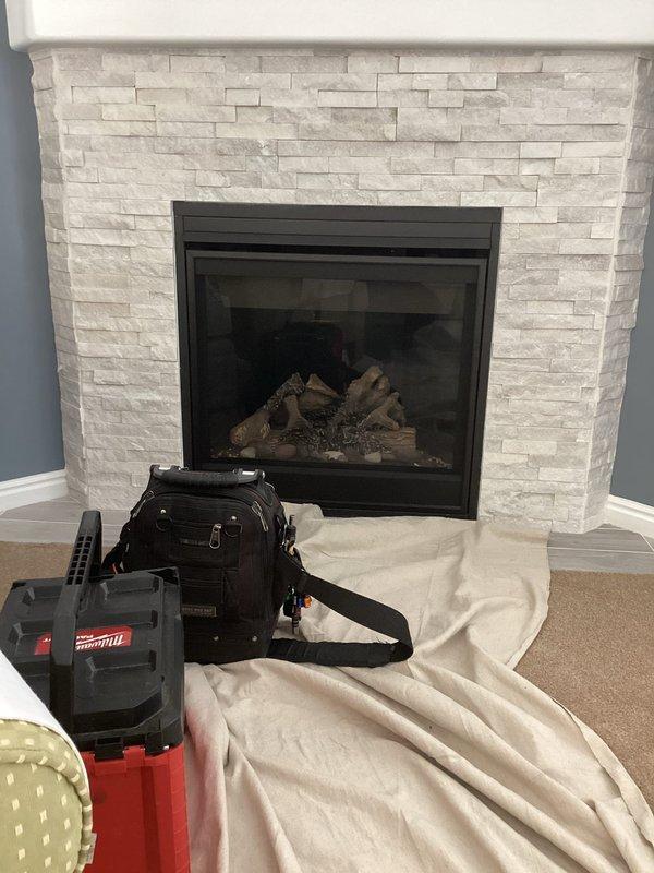 Completed comprehensive maintenance and tune-up service on gas fireplace with stacked stone surround in residential living room. Performed full system inspection, cleaned glass panel and burner assembly, verified proper flame pattern and ignition operation, and tested all safety controls to ensure optimal performance. No issues were identified during the service call, and unit was left in excellent working condition.