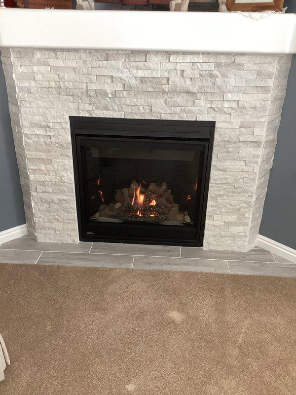 Completed comprehensive maintenance and tune-up service on gas fireplace with stacked stone surround in residential living room. Performed full system inspection, cleaned glass panel and burner assembly, verified proper flame pattern and ignition operation, and tested all safety controls to ensure optimal performance. No issues were identified during the service call, and unit was left in excellent working condition.