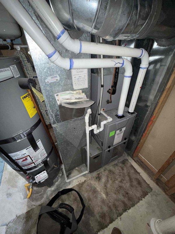 Responded to service technician referral for 14-year-old furnace and heat pump system. Upon inspection, confirmed heat exchanger exhibited significant rust deterioration and structural concerns requiring immediate attention. Documented existing HVAC equipment configuration including furnace unit, water heater, ductwork connections, and condensate drainage system with comprehensive photographic evidence. Measured equipment dimensions and assessed installation clearances in basement mechanical room. System evaluation determined replacement recommendation due to age of equipment and severity of heat exchanger corrosion, which poses potential safety hazards and operational inefficiency.