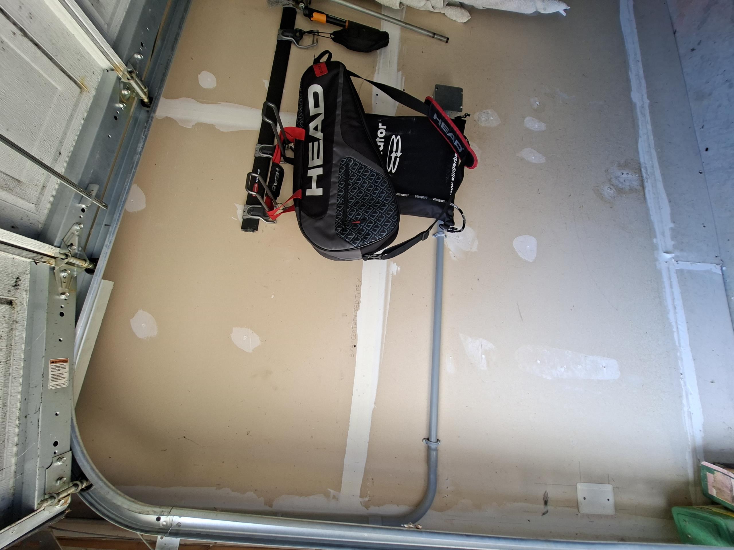 Remove existing faulty Tesla charger and run circuit extension from existing charger to new charger installation between garage doors. A junction box will be installed at current charger location, and a circuit extension ran in PVC conduit will be ran from the junction box to new charger location. New Tesla charger will be installed flushly between the doors. PVC conduit will be ran horizontally from the junction box, then vertically to allow clearance of the garage door. 

Completed car charger and gave solution to install an outlet behind TV in basement.