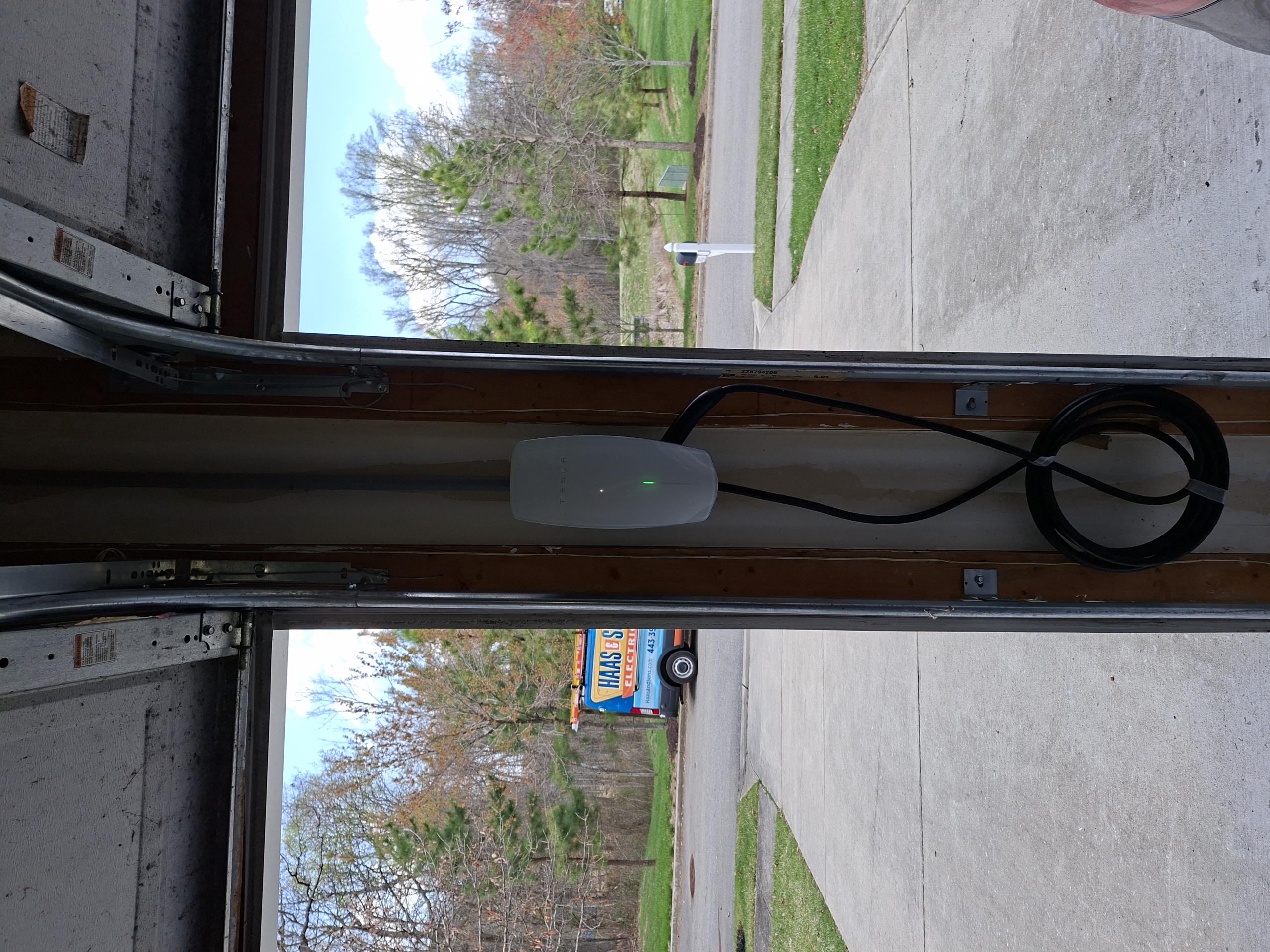 Remove existing faulty Tesla charger and run circuit extension from existing charger to new charger installation between garage doors. A junction box will be installed at current charger location, and a circuit extension ran in PVC conduit will be ran from the junction box to new charger location. New Tesla charger will be installed flushly between the doors. PVC conduit will be ran horizontally from the junction box, then vertically to allow clearance of the garage door. 

Completed car charger and gave solution to install an outlet behind TV in basement.