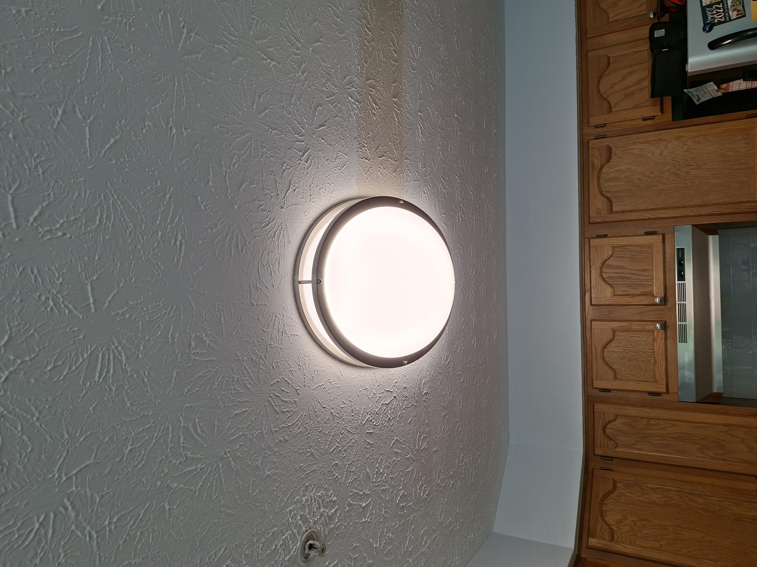 Install two customer supplied lights in the kitchen and outside the front door. Install customer supplied timer switch. 

Called out today to install two customer supplied lights and install timer switch and to determine what caused the front light to stop working. Taking down the front light, I discovered a wasp nest inside the light box, with damage to the insulation on the hot conductor. I cut this conductor back and spliced extra wire to it, and install the light and switch, and the light worked. I removed the old fluorescent light in the kitchen and replaced it with a customer supplied LED light, set to 4000 Kelvin.