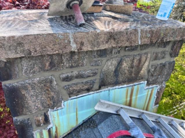Leaking chimney with heavy cast crown that had many deep cracks and pooling areas around tiles.  Crown removal would have caused the need to completely rebuild the top of this stone chimney.  Best solution in this case was to repoint all the mortar joints, install a water-impermeable crown seal, and apply an industrial-grade water repellant.