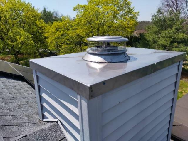 Leaking and rusty chase pan and cap on a prefabricated chimney replaced with all new stainless steel in Meriden - New Haven County