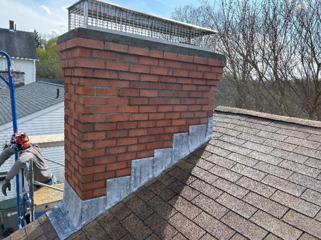 This chimney had loose bricks and missing mortar. Chimney rebuild in Manchester, CT, including flashing, crown and cap.

