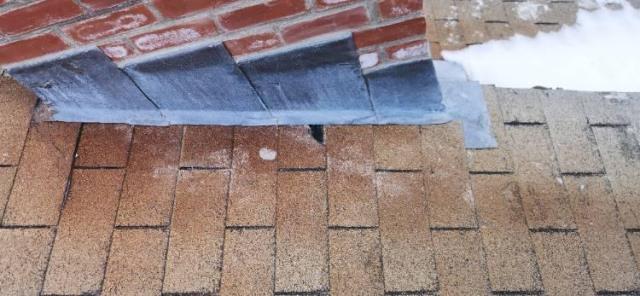 Chimney with spalled and popped brick due to water penetration, flashing was previously tarred over.  Rebuilt with custom aged looking brick, with new proper roof flashing.