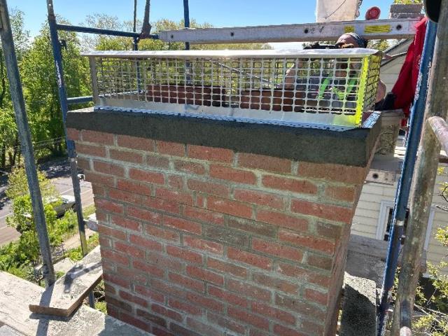 Older water stained and deteriorated New Haven Ct chimney that vented both the oil and fireplace flues. Had past issue with birds. Rebuilt chimney and installed animal guard chimney cap.