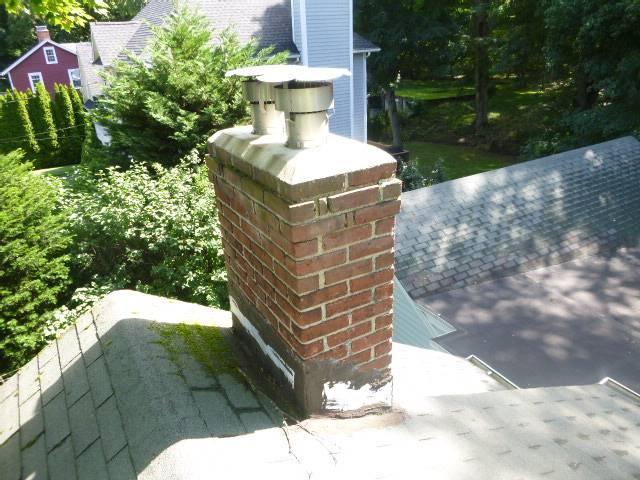The top of the chimney has structural damage, open joints, and a fractured crown, likely worsened by a previous cover-up, leading to trapped moisture and accelerated deterioration. To stop further damage, the entire chimney top needs to be rebuilt down to the roofline with new materials and proper flashing.