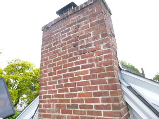 Bridgeport CT Top Of The Chimney Has Saturation and Structural Damages Developing Down to the Lower Roofline. Performed a roof up rebuild with new brick, cement, flashing, cap, and crown.