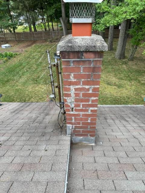 This Enfield Ct chimney needed a full roof-up rebuild. The old structure was cracking, leaking, and even had an old TV antenna bolted to it. We rebuilt the chimney from the roofline up, installed new flashing, and removed the antenna for a cleaner, watertight finish.