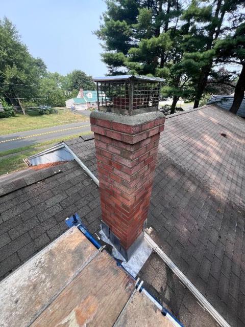 This Enfield Ct chimney needed a full roof-up rebuild. The old structure was cracking, leaking, and even had an old TV antenna bolted to it. We rebuilt the chimney from the roofline up, installed new flashing, and removed the antenna for a cleaner, watertight finish.