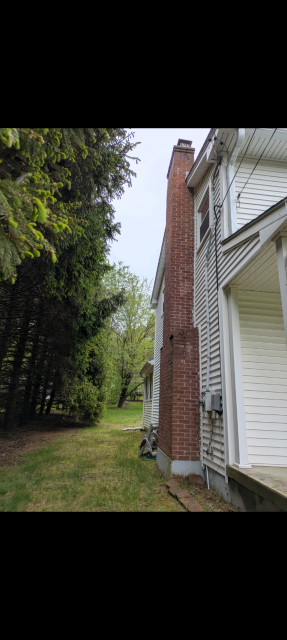 In South Windsor, CT, today, We rebuilt the top of the chimney and replaced damaged flue tiles to stop acidic exhaust from causing further deterioration. Mortar joints were repointed, and stainless steel caps reinstalled to preserve the structure.