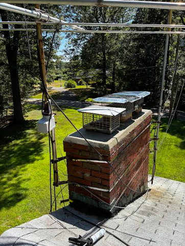 In Manchester, CT, we replaced the deteriorated chimney crown and installed new stainless steel caps to prevent water and animal entry. We cleaned the masonry and applied two coats of water repellent to protect against future moisture damage.