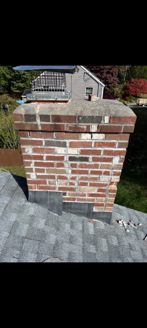 In Groton CT We removed the damaged chimney structure down to the roofline and rebuilt it with all new brick, cement, and flashing. We reconstructed the crown with a proper drip edge and installed a stainless steel cap to protect the flue.