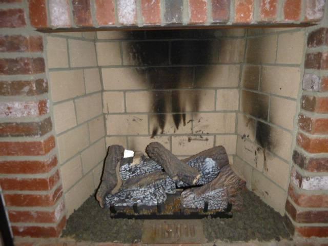 Removed propane log set, capped line, and prepared fireplace. Installed flush wood stove insert with full insulated liner for safe venting.