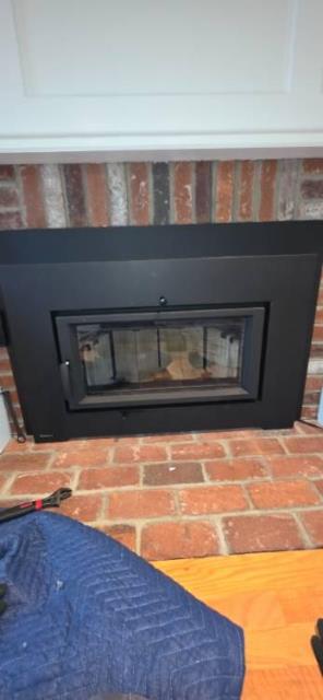 Removed propane log set, capped line, and prepared fireplace. Installed flush wood stove insert with full insulated liner for safe venting.