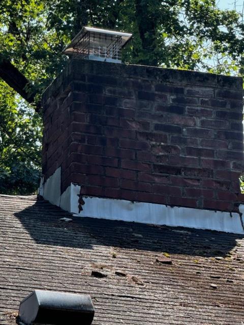 In Hartford, CT, the chimney has suffered extensive exterior damage from years of water penetration and freeze/thaw cycles, resulting in cracked bricks, missing mortar, and compromised structural integrity requiring a full rebuild from the roofline up. The project includes proper lead flashing installation, a new top flue tile, cement crown, and high-quality masonry work to prevent future leaks and deterioration.