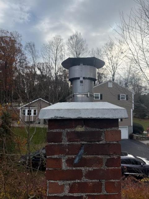 In New Milford CT, We installed a UL Listed stainless steel chimney liner system to prevent further damage to the failing clay tile flue. We also replaced the cracked crown with a new precast cement crown.