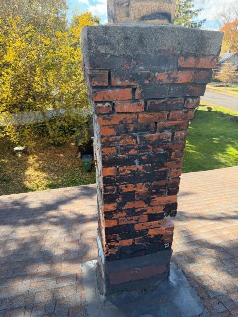 We rebuilt chimney from roofline up with new brick, mortar, flue section, crown, and lead flashing. We addressed water damage and structural failure.