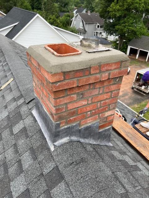 Roof up rebuild in West Hartford, CT with new brick, cement, flashing, flue tiles, crown, and a stainless cap going in to restore safety and function!