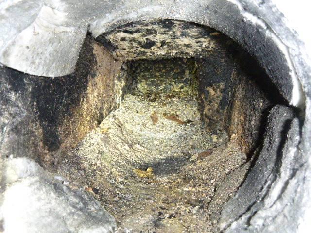 In Windsor, CT, the high-efficiency Beckett AFG oil burner is causing condensation that mixes with soot, forming sulfuric acid, which has damaged the chimney’s flue tiles and mortar joints, allowing exhaust and moisture to bypass the venting system. To fix this, a stainless steel 2-ply smoothwall liner was installed to ensure safe venting and protect the chimney structure. Additionally, the fractured and eroded cement crown was removed and replaced to properly shed water and prevent further structural damage.