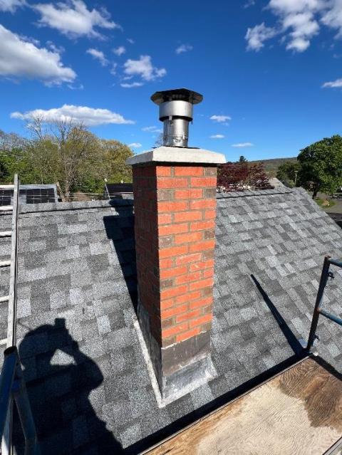 Roof up chimney rebuild in Southington Ct  - with new lead flashing , new brick and mortar and a precast crown