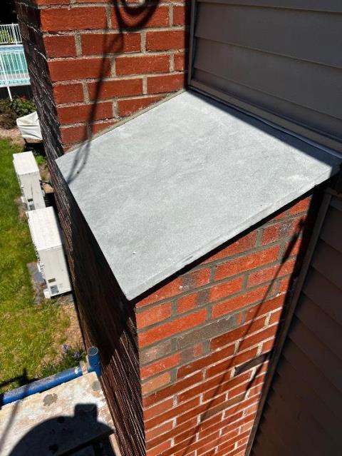 We rebuilt the chimney shoulder with new brick and bluestone, and applied a water repellent to protect the masonry exterior.