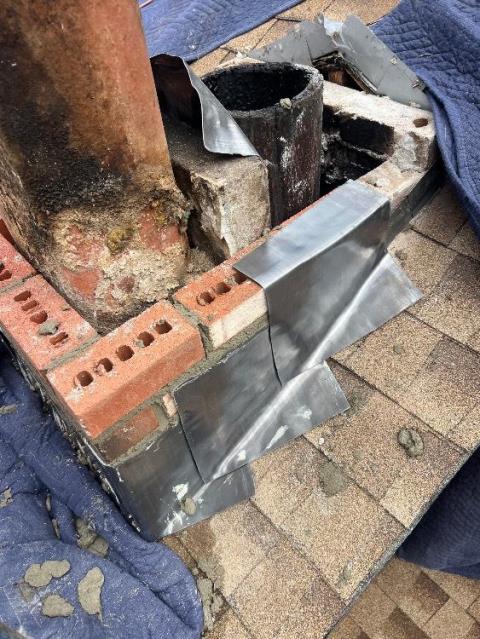 Interior of chimney was deteriorated with areas of melted mortar , allowing hot flue gasses from stove and furnace to escape between tiles. Woodstove side was filled with glazed creosote which a routine chimney sweep , can’t remove.  We performed a rotary deglaze with specialized wire whips and high speed drill. We then began rebuilding the chimney roofline up and installing a gas tight chimney liner system. 