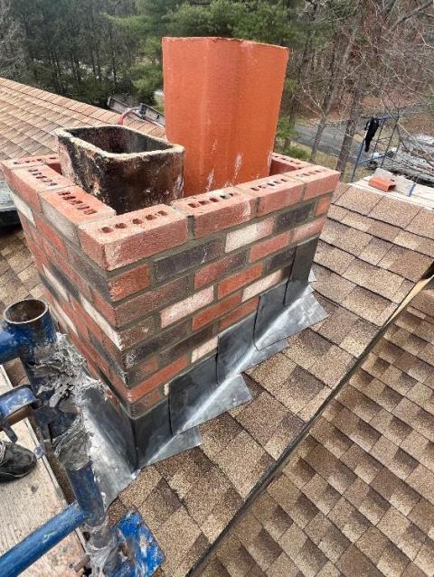 Interior of chimney was deteriorated with areas of melted mortar , allowing hot flue gasses from stove and furnace to escape between tiles. Woodstove side was filled with glazed creosote which a routine chimney sweep , can’t remove.  We performed a rotary deglaze with specialized wire whips and high speed drill. We then began rebuilding the chimney roofline up and installing a gas tight chimney liner system. 