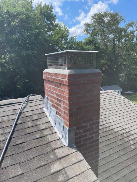 Severe spalling, open mortar joints, crown failure, and loose masonry were allowing water intrusion. We’re rebuilding to the roofline with new brick, flashing, crown, flue tiles, and a stainless cap.