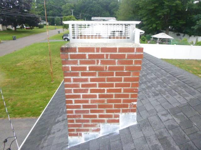 Sulfuric-acid condensation, a fractured crown, open mortar joints, and moss were accelerating deterioration. We’re rebuilding the crown, repointing joints, and applying water repellent to protect the masonry.