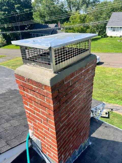 Sulfuric-acid condensation, a fractured crown, open mortar joints, and moss were accelerating deterioration. We’re rebuilding the crown, repointing joints, and applying water repellent to protect the masonry.