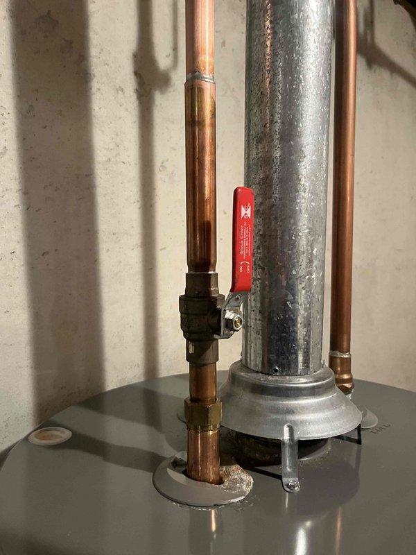 Inspected 9-year-old Rheem water heater with severely corroded fitting at the top connection point. Documented extensive deterioration where copper pipe meets brass fitting, with visible mineral deposits and rust indicating a slow leak. Provided client with repair options and replacement estimate as requested.