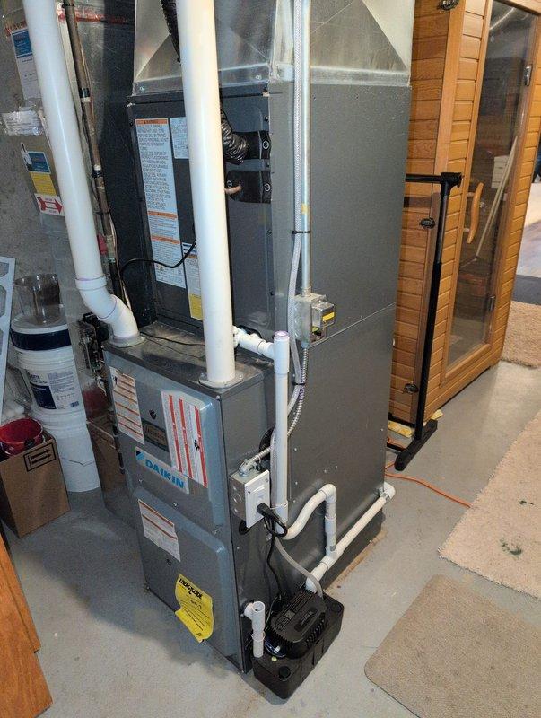 Responded to inspector correction by rerouting sump pump drain line to sanitary drain system. Installed condensate pump with integrated GFCI combo plug and added proper drain trap to ensure code compliance. System now properly drains from the Daikin HVAC equipment in basement utility room without risk of backflow.