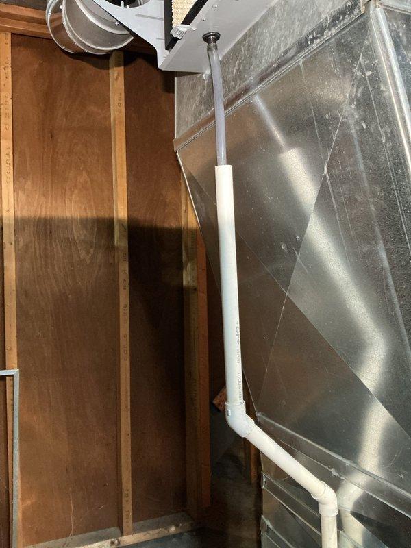 Responded to water leak complaint at furnace base pan. Inspected HVAC system and discovered condensate drain line blockage causing water accumulation. Cleared obstruction in PVC drainage pipe connected to ductwork and verified proper drainage function. Serviced humidifier which was not operating due to related drainage issues. System now functioning properly with no visible leaks.