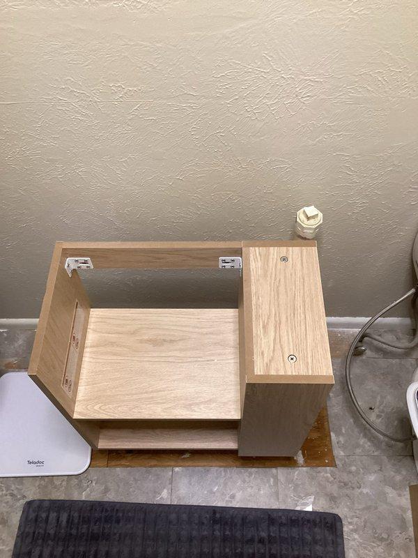 Conducted site evaluation for plumbing relocation project involving two copper supply lines and one drain line. Client requires lines to be moved 6-10 inches left of current position to accommodate installation of new smaller sink. Documented existing cabinet configuration and plumbing access points to facilitate proper planning of line repositioning work.