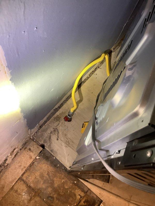 Relocated yellow corrugated gas line that was interfering with cabinet installation. Properly reconnected line to existing valve and verified secure connection to HVAC equipment. Final inspection confirmed no leaks and proper gas flow to unit.