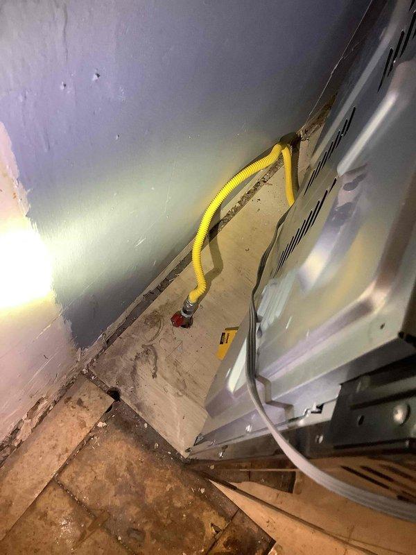 Relocated yellow corrugated gas line that was interfering with cabinet installation. Properly reconnected line to existing valve and verified secure connection to HVAC equipment. Final inspection confirmed no leaks and proper gas flow to unit.
