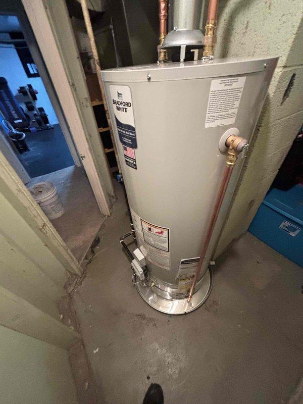 Successfully installed a new Bradford White water heater in utility room, replacing existing unit. Completed all necessary plumbing connections including copper inlet/outlet lines and installed proper control valve. System is operational with all connections secure.