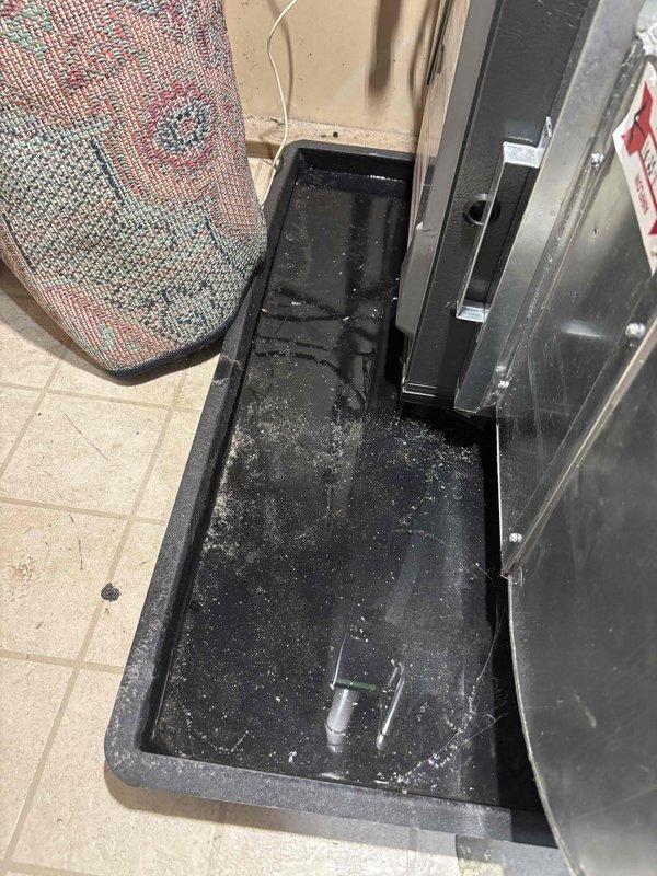 Responded to customer report of water leaking from furnace. Inspection revealed condensate collection pan containing water and debris beneath HVAC unit. Checked drainage system including PVC piping and ductwork connections. Cleared blockage in condensate drain line, cleaned collection pan, and verified proper drainage function to resolve leak issue.