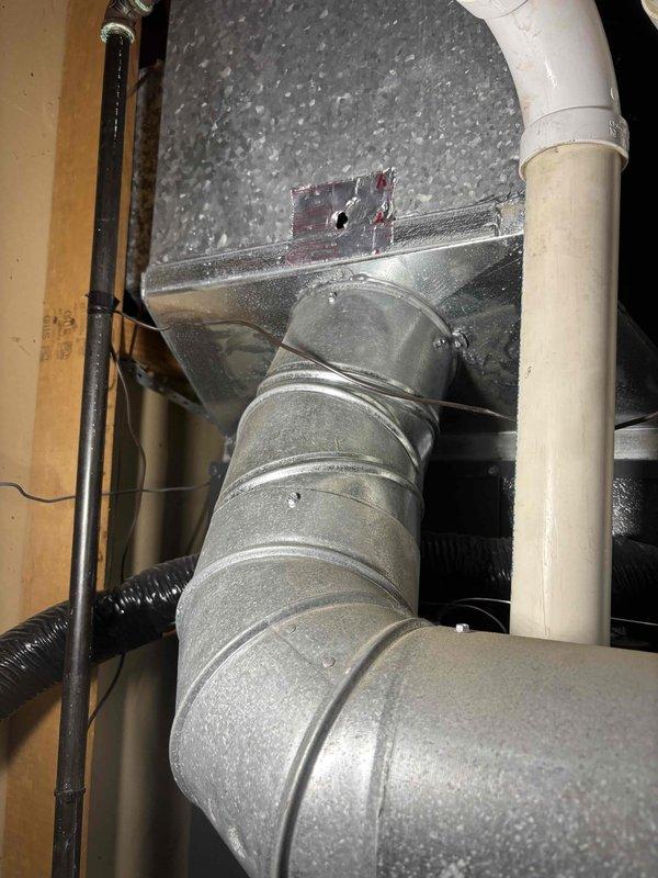 Responded to customer report of water leaking from furnace. Inspection revealed condensate collection pan containing water and debris beneath HVAC unit. Checked drainage system including PVC piping and ductwork connections. Cleared blockage in condensate drain line, cleaned collection pan, and verified proper drainage function to resolve leak issue.