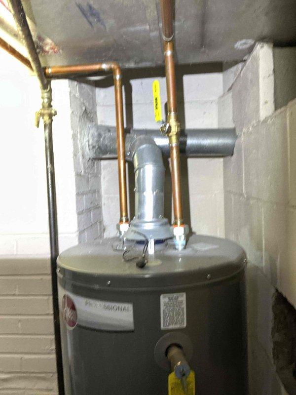Conducted water heater assessment for a family of 6 at property owned by Hope Church of Kalamazoo. Evaluated existing Rheem Professional unit showing signs of deterioration and documented current installation with copper piping and PVC drain configuration. Prepared estimate for replacement with larger capacity water heater to accommodate household needs, along with separate quote for unrelated plumbing re-route work as requested.