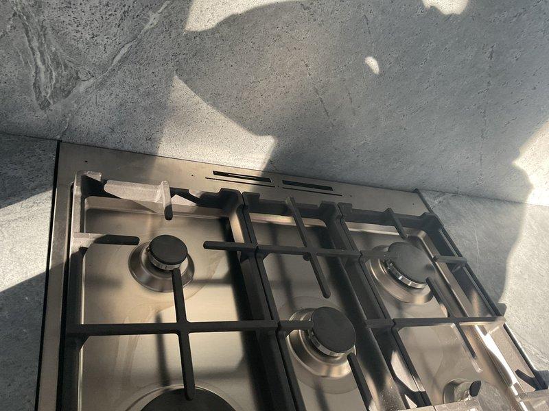 Successfully installed new gas line from basement to kitchen stove location, including proper appliance connector and shut-off valve as quoted. Completed installation in basement with exposed piping properly secured to joists, ensuring safe connection to the stainless steel cooktop with four burners.