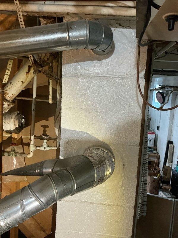 Conducted an assessment for potential installation of a combination tankless water heater/boiler system to replace existing 16-year-old boiler. Inspected current mechanical room setup, noting aging water heater with significant corrosion at pipe junctions, particularly at the iron pipe cross fitting. Documented existing HVAC ductwork configuration and plumbing connections to determine appropriate specifications for the proposed system upgrade.