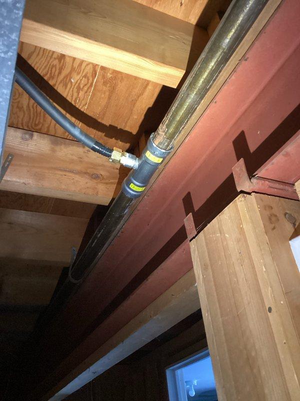 Returned to complete gas line installation as requested. Successfully ran a new gas line through structural framing, ensuring proper support along wooden beams with appropriate labeling. Connected the yellow gas line to a brass fitting mounted on a floor plate in the renovation area, completing the CWOW service requirement.