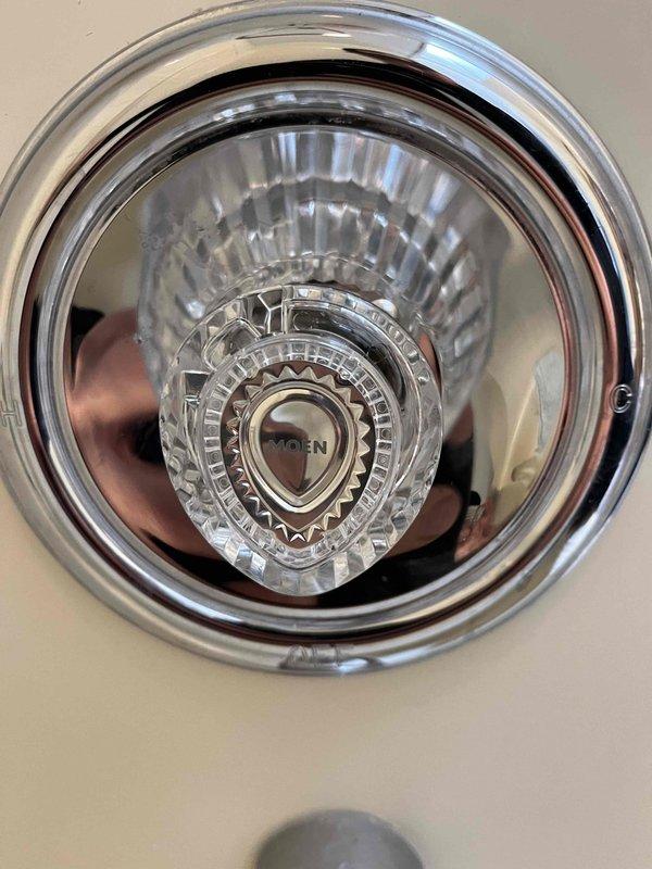 Completed installation of Moen shower/tub fixture components on fiberglass enclosure as quoted. Successfully installed chrome shower control handle with glass decorative center dial, chrome tub spout with diverter switch, and drain stopper mechanism. All components properly secured and functioning as intended with no leaks observed upon final inspection.