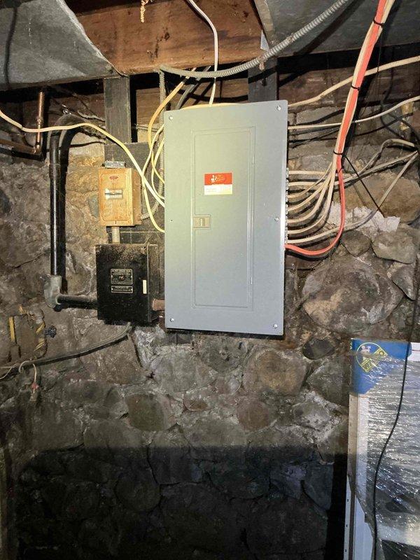Inspected separated pole mast caused by falling ice damage. Evaluated electrical panel connections in basement to ensure integrity of service was maintained despite exterior mast separation. Documented existing installation with photos for accurate repair estimation.