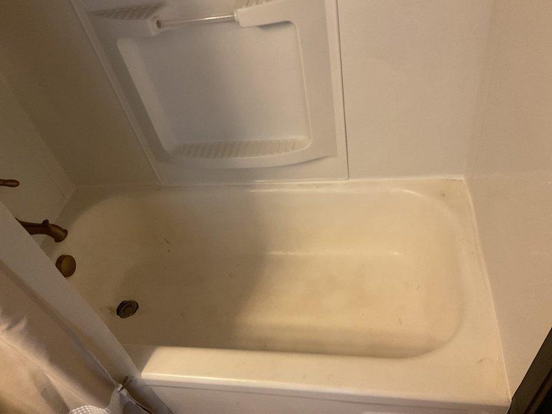 Completed bathtub and shower resealing service in bathroom. Addressed visible discoloration and water staining around tub surfaces and shower drain area. Applied professional-grade sealant to both units, restoring water-tight integrity and improving overall appearance.