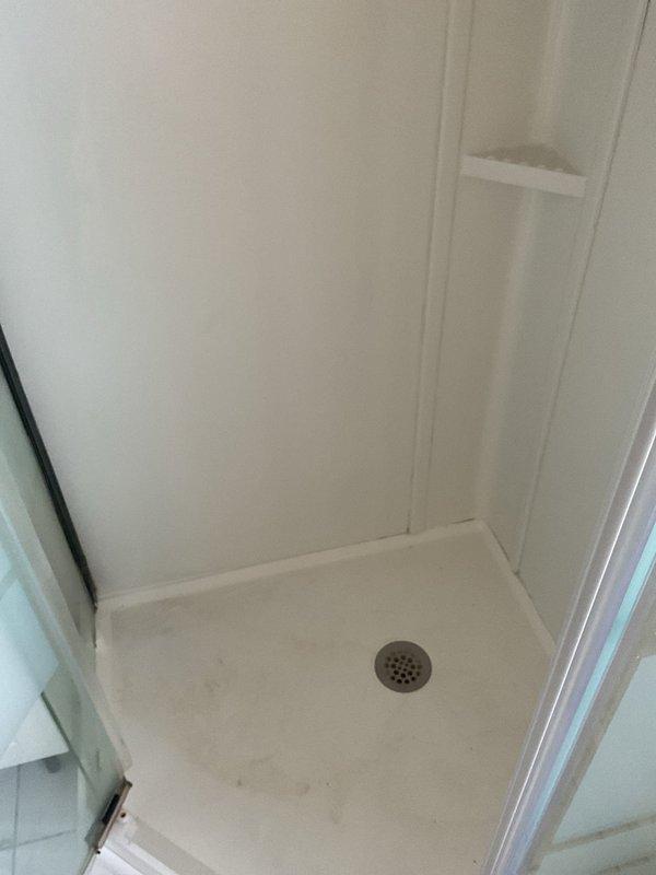 Completed bathtub and shower resealing service in bathroom. Addressed visible discoloration and water staining around tub surfaces and shower drain area. Applied professional-grade sealant to both units, restoring water-tight integrity and improving overall appearance.