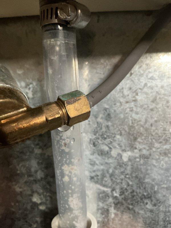Diagnosed and repaired water leak from humidifier connected to 12-year-old EcoAir furnace system. Identified failed water supply connection with visible bubbling in clear tube and water droplets on brass valve assembly. Replaced damaged components and verified proper operation of humidifier with no further leakage.